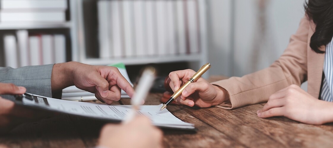 The hands of two people on a document being read