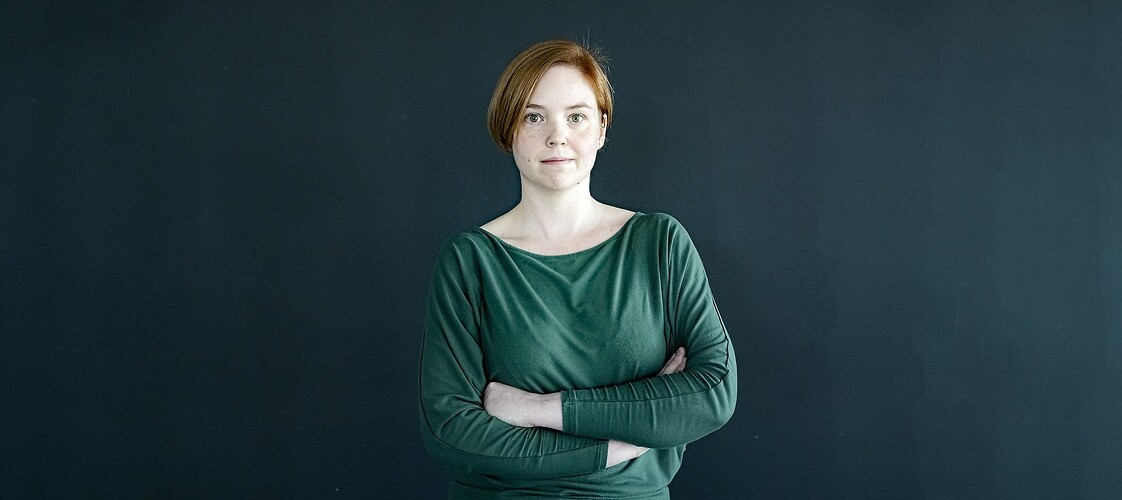 Kobieta na ciemnym tle, Magdalena Dydyszko, główny specjalista, koordynator ds. dostępności, Departament Polityki Konsum