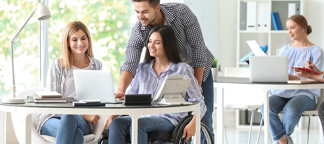Kobieta na wózku i mężczyzna przy laptopie