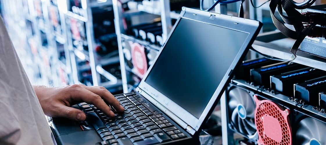 Ręce trzymające laptop w serwerowni