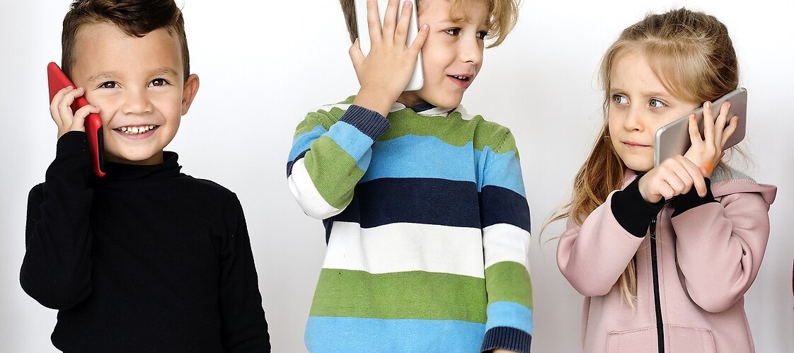Trójka dzieci z telefonem komórkowym przy uchu