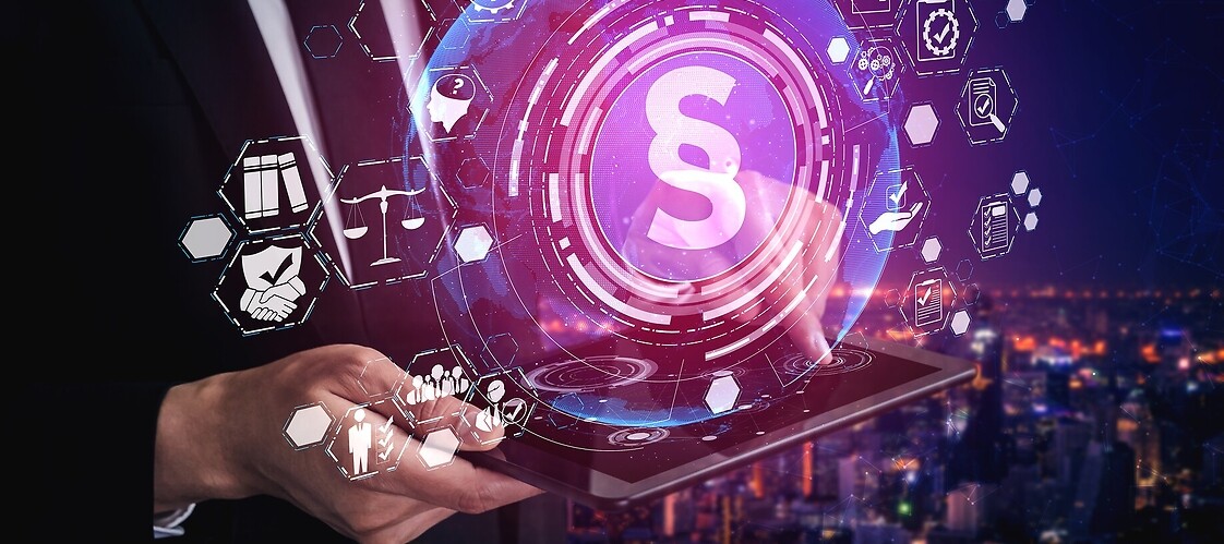 Dłonie, nad którymi wyświetlają się ikony zwia,żane z internetem i prawem, w środku znak paragrafu