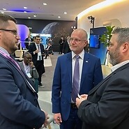 Trzech męzczyznw garniturach w przestrzeni konferencyjnej