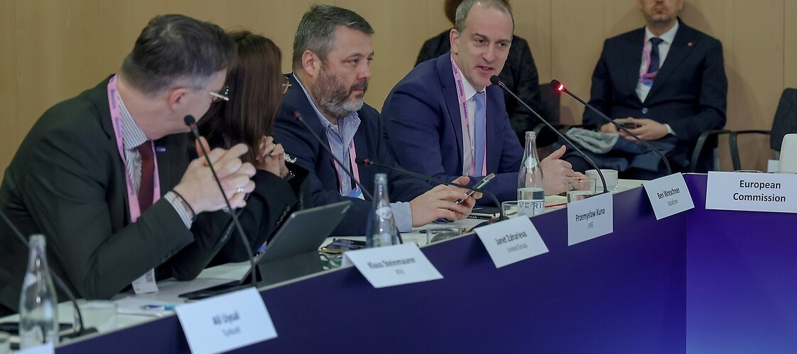 Grupa osób w garniturach za stołem konferencyjnym