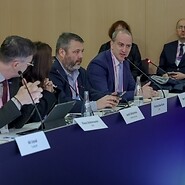 Grupa osób w garniturach za stołem konferencyjnym