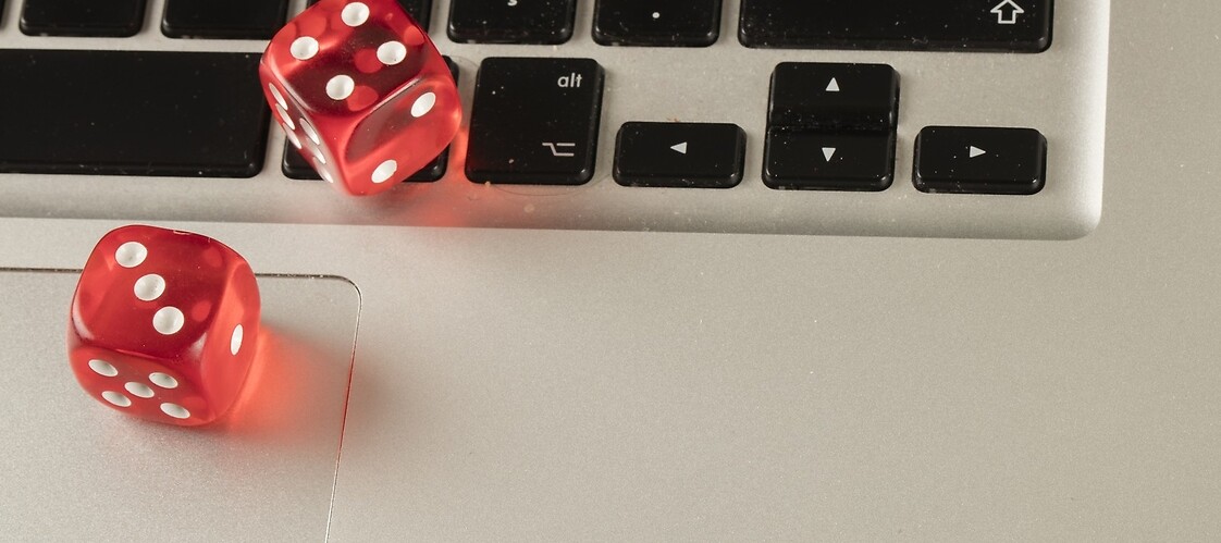 Czerwone kości do gry leżą na klawiaturze laptopa