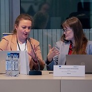 Dwie osoby za stołem w sali konferencyjnej