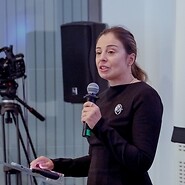 Kobieta z mikrofonem w sali konferencyjnej