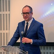 Mężzyzna z mikrofonem w sali konferencyjnej