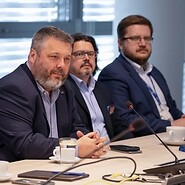 Trzech mężczyzn za stołem konferencyjnym