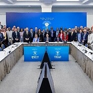 Zdjęcie zbiorowe, długi stół konferencyjny w kształcie litery U, za nim ...