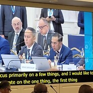 Kadr z telebimu: grupa mężczyzn za stołami konferencyjnymi, w drugim rzędzie ...