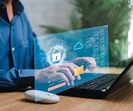 Ręce na klawiaturze, na pierwszym planie infografika z okona cyberbezpieczeństwa