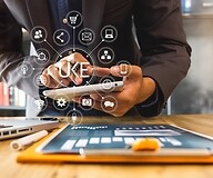 Dłonie męzczyzny trzymają smartfon, na pierwszym planie ikony usług cyfrowych, ...